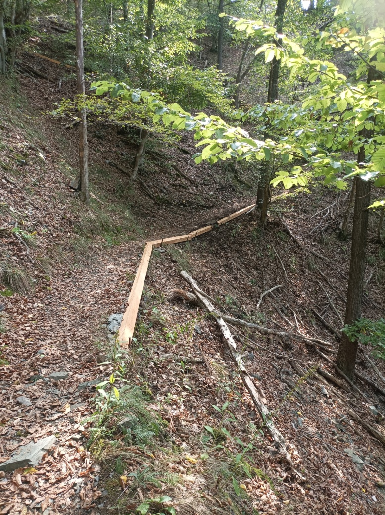 Stezka ve stráni s položeným hranolem.