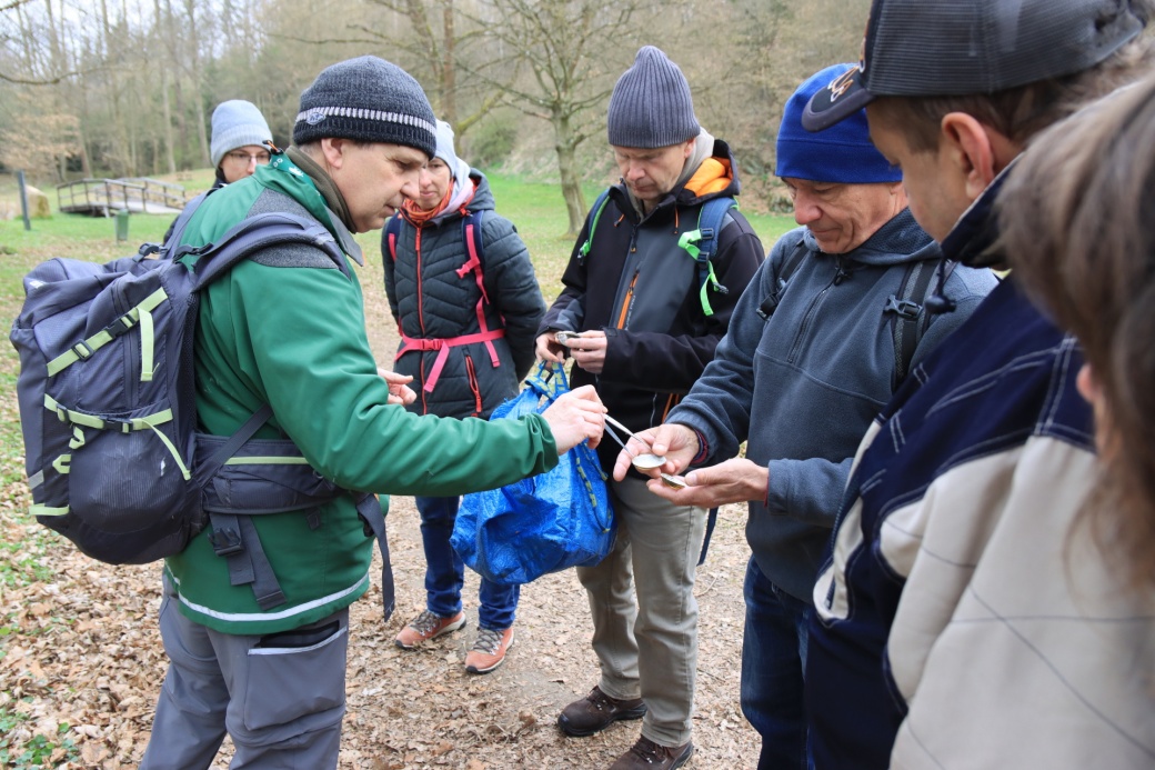 Účastníci vycházky si prohlížejí schránky škeblí.
